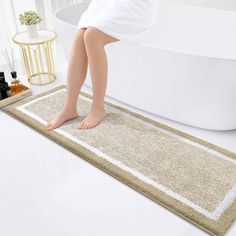 a person standing on a bath mat in front of a bathtub with the feet propped up