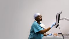 a woman in scrubs is operating a monitor