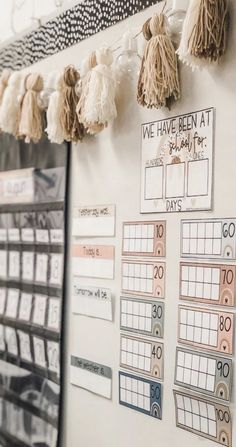 a white wall with some tassels hanging from it's sides and calendars on the wall