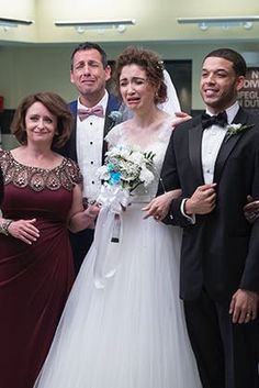 a group of people standing next to each other in formal wear and tuxedos