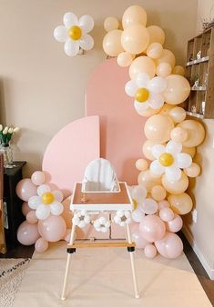 a baby's room decorated with balloons and flowers in pastel pink, white and gold colors