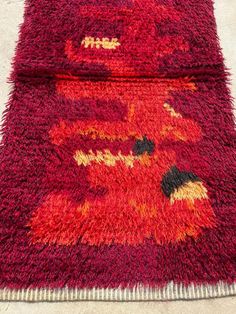 two red rugs sitting on top of a carpet covered in lots of different colors