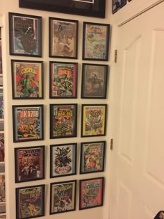 a bunch of comics are hanging on the wall next to a door in a room