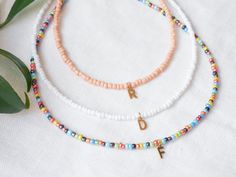 Initial seed bead necklace is so cute and versatile! Light-weight and dainty, with small 3 mm seed beads and a gold stainless steel initial of your choice.  Pretty on it's own and also fantastic for layering. Lovely gift idea! You can choose from three beautiful colors: Colorful, white and peach. The length of this necklace is 15 inches, with a 2 inches (5 cm) extension chain - so you can adjust the length of your necklace between 15 inches and 17 inches (38 - 43 cm). If you would like to have the necklace shorter or longer, just send me a message - I'm happy to personalize this necklace for you. The beading wire is high-quality stainless steel. The other metal parts are gold-plated/stainless steel. Also available silver-plated with a stainless steel (dark silver tone) initial, just send m Minimalist Beaded Necklace With Round Letter Beads, Minimalist Beaded Necklace With Letter Beads, Custom Birthday Gifts, Rainbow Jewelry, Beading Wire, Colorful Rainbow, Seed Bead Necklace, Custom Birthday, Beaded Necklaces