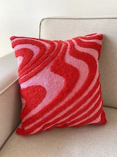 a red and white pillow sitting on top of a couch