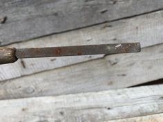 an old rusted metal handle on a wooden wall