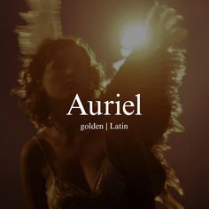 a woman standing in front of a light with the words auriel written on it