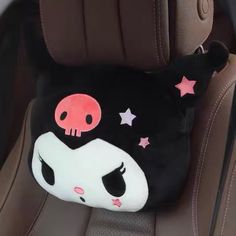 a black and white pillow sitting on top of a car seat with pink stars around it