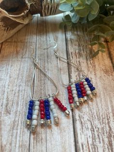 Hand beaded, red white and blue seed bead dangles on a triangular shaped base. The earrings  measure approximately 2.5 inches high and 3 inches long including the ear wire. Patriotic Beaded Dangle Earrings, Patriotic Dangle Beaded Earrings, Patriotic Jewelry, Bead Dangles, Lake Geneva, Beaded Dangles, Hand Beading, Ear Wire, Red White And Blue