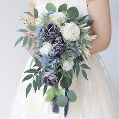 a bridal holding a bouquet of flowers and greenery