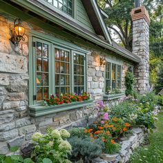 an outside view of a house with flowers in the window boxes and landscaping around it