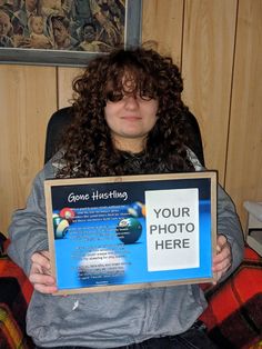 a woman sitting in a chair holding up a sign