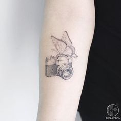 a tattoo with a camera on the arm