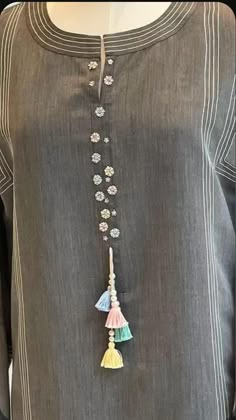 a woman's gray top with tassels and beads