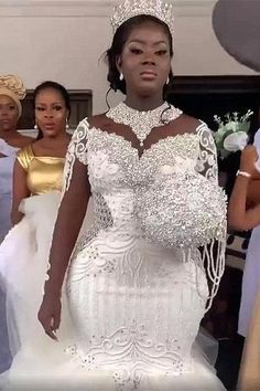 a woman in a wedding dress standing next to other women wearing dresses and tiaras