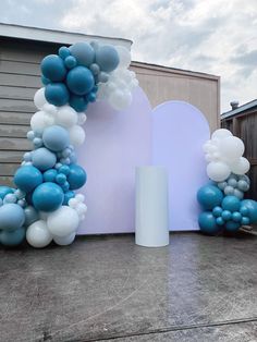 blue and white balloons are on display in front of a large arch