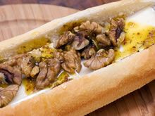 a hot dog with nuts and mustard on it