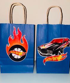 two blue shopping bags with hot wheels stickers on the handles and sides, one has a red car