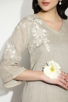 Natural beige anchor thread hand embroidered tunic featuring 3D embossed gold petal floral work. Paired with a pant. - Aza Fashions Elegant Linen Kurta For Spring, Elegant Resham Embroidery Tunic For Spring, V-neck Kurta With Floral Embroidery For Spring, Spring V-neck Kurta With Floral Embroidery, Floral Embroidery V-neck Kurta For Spring, Elegant Linen Tops With Floral Embroidery, Elegant Tunic Top With Floral Embroidery, Elegant Summer Tunic With Floral Embroidery, Spring Beige Kurta With Chikankari Embroidery