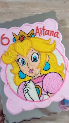 a close up of a cake with a princess on it's face and name