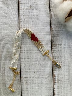 a white and red beaded lanyard on a wooden surface