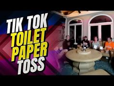 a group of people sitting around a table in front of a window with the words tik tok toilet paper toss