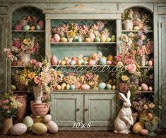 an easter scene with flowers, eggs and a bunny sitting in front of a hutch