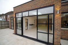 an empty room with glass doors and brick walls