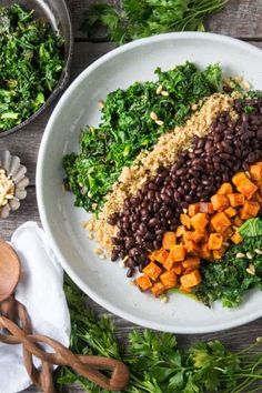 a white plate topped with black beans and veggies next to other food items