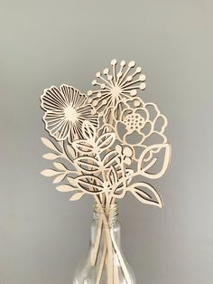 a vase filled with cut out flowers on top of a white tablecloth covered floor