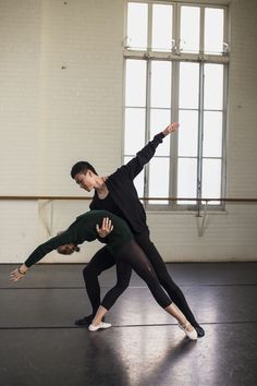 two dancers in black and green pose for the camera