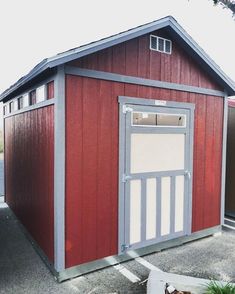 a small red shed sitting on top of a parking lot