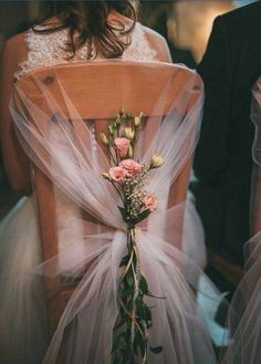 the back of a bride's chair with flowers on it