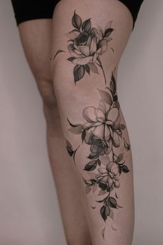 a woman's leg with flowers on it, and the bottom part of her thigh