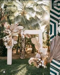 an outdoor ceremony setup with palm trees and flowers