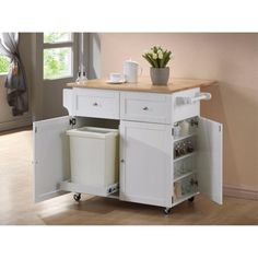 a white kitchen island with two trash cans on it's wheels and a wooden top