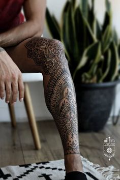 a person sitting on top of a rug next to a potted plant