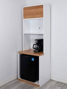 a white shelf with a black coffee maker on top and a wooden table underneath it