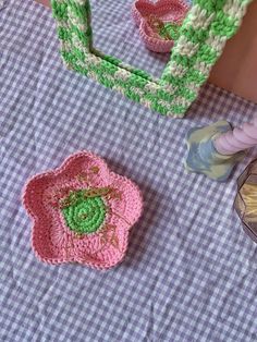 two crocheted items sitting on top of a purple and white checkered table cloth