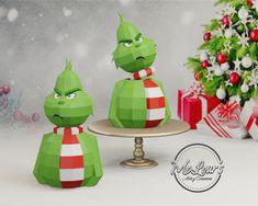 an origami christmas scene with two green figures