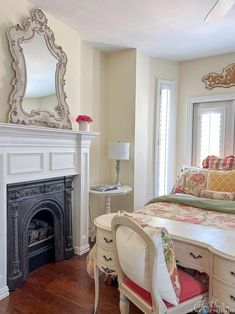 a bedroom with a bed, mirror and fireplace