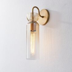 a light that is on the wall next to a white wall with a glass tube