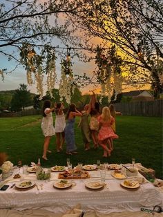 a group of people standing around a table covered in plates and bowls with food on it