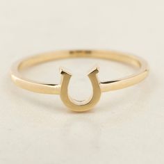 Our Handmade 14K Solid Gold Horseshoe Ring is a fusion of elegance and a timeless symbol of good luck. Exquisitely crafted from 14K solid gold, this dainty ring is an embodiment of fine craftsmanship and meaningful design. The horseshoe, measuring 6.25 mm by 5.8 mm, is perfectly proportioned to add a touch of charm to your daily attire without being overpowering. Available in a range of colors – the classic sheen of gold, the soft glow of rose gold, or the sleek allure of white gold – this ring Horse Shoe Ring, Meaningful Design, Horseshoe Ring, Timeless Symbol, Dainty Ring, Charm Gift, Exquisite Jewelry, Lucky Charm, Real Gold