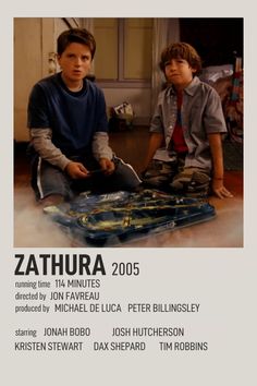 two young boys sitting on the floor in front of a poster for zathura