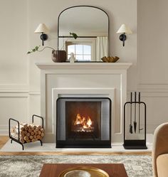 a living room with a fire place in the center and mirror on the wall above it