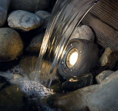 a water spouting from a light on some rocks