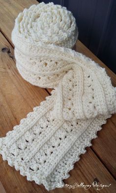 a white crocheted scarf sitting on top of a wooden table