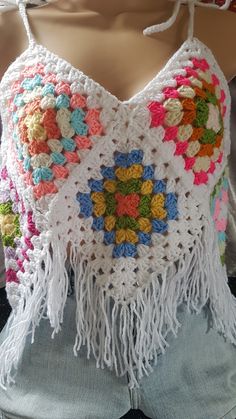 a crocheted top with multicolored flowers and fringes on the shoulders