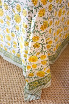 a bed with yellow flowers on it and a green border around the headboard cover